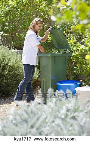 Stock Photo - Woman looking into recycling bin. Fotosearch
