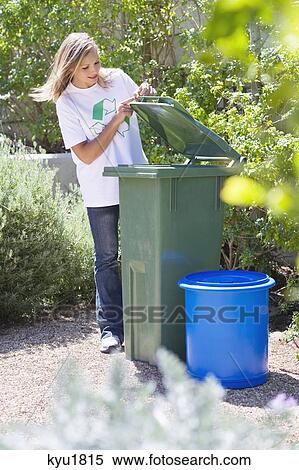 Stock Photography - Woman looking into recycling bin. Fotosearch