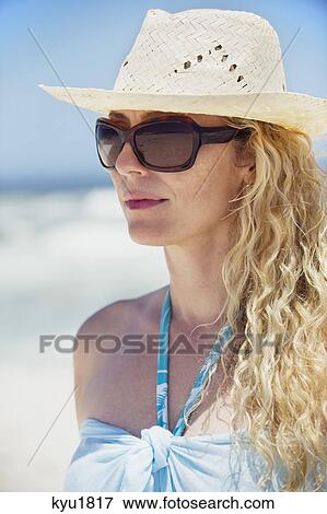 Woman wearing sunglasses and sunhat View Large Photo Image Stock Photo - Woman wearing sunglasses and sunhat. Fotosearch