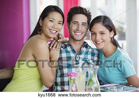 Women sitting with hand on a man's shoulders in restaurant View Large Photo Image Stock Photo - Women sitting with hand on a man's shoulders in restaurant. Fotosearch