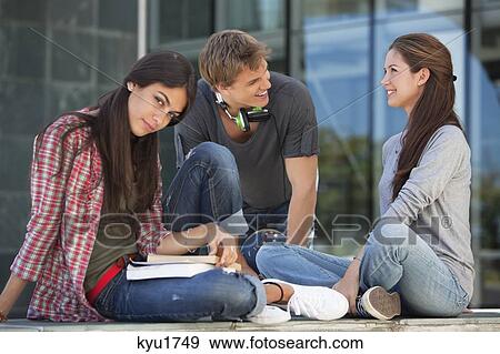 Stock Photo - Young students having discussion and smiling. Fotosearch