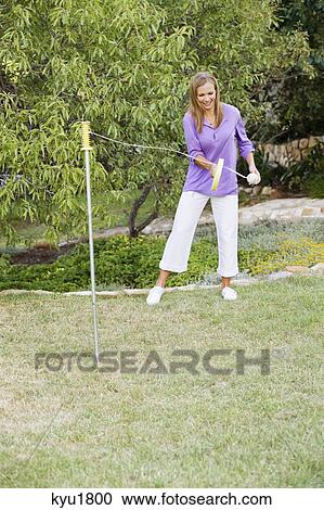 Young woman playing paddle ball in a garden View Large Photo Image Stock Image - Young woman playing paddle ball in a garden. Fotosearch