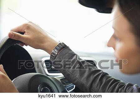 Stock Image - Young woman taking a test drive. Fotosearch