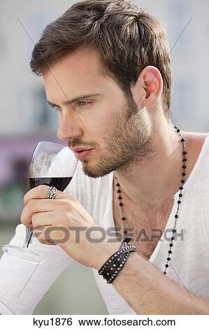 Stock Photograph - Close-up of a man drinking red wine, Paris, Ile-de-France, France. Fotosearch