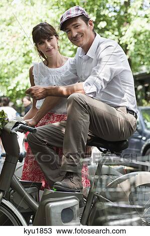 Couple riding bicycles and smiling, Paris, Ile-de-France, France View Large Photo Image Stock Image - Couple riding bicycles and smiling, Paris, Ile-de-France, France. Fotosearch