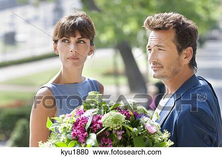 Stock Image - Couple with a bouquet of flowers, Paris, Ile-de-France, France. Fotosearch