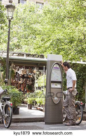 Man looking a map in a ticket machine, Paris, Ile-de-France, France View Large Photo Image Stock Photo - Man looking a map in a ticket machine, Paris, Ile-de-France, France. Fotosearch