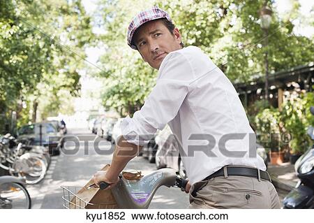 Stock Image - Man riding a bicycle, Paris, Ile-de-France, France. Fotosearch