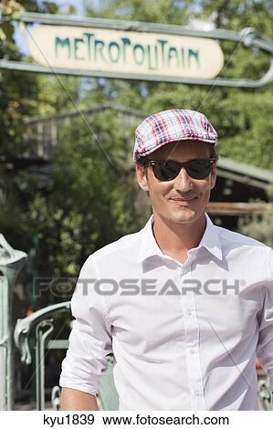 Stock Photo - Man wearing a flat cap and smiling, Paris, Ile-de-France, France. Fotosearch