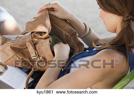 Stock Image - Woman checking her purse, Paris, Ile-de-France, France. Fotosearch