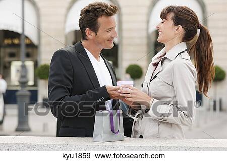 Stock Photo - Woman giving a present to a man, Paris, Ile-de-France, France. Fotosearch