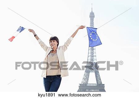 Woman holding a European Union flag and a French flag with the Eiffel Tower in the background, Paris, Ile-de-France, France View Large Photo Image Stock Image - Woman holding a European Union flag and a French flag with the Eiffel Tower in the background, Paris, Ile-de-France, France. Fotosearch