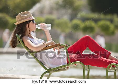 Woman sitting in a chair and drinking water, Bassin octogonal, Jardin des Tuileries, Paris, Ile-de-France, France View Large Photo Image Stock Photo - Woman sitting in a chair and drinking water, Bassin octogonal, Jardin des Tuileries, Paris, Ile-de-France, France. Fotosearch
