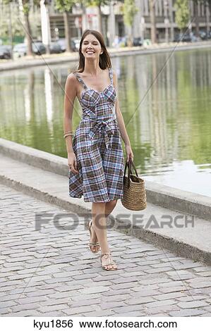 Woman walking near a canal and smiling, Paris, Ile-de-France, France View Large Photo Image Stock Photograph - Woman walking near a canal and smiling, Paris, Ile-de-France, France. Fotosearch