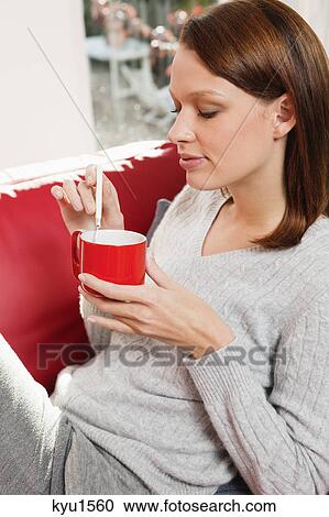 Stock Image - Young woman drinking coffee. Fotosearch