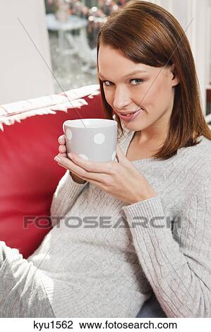 Stock Image - Young woman drinking coffee. Fotosearch