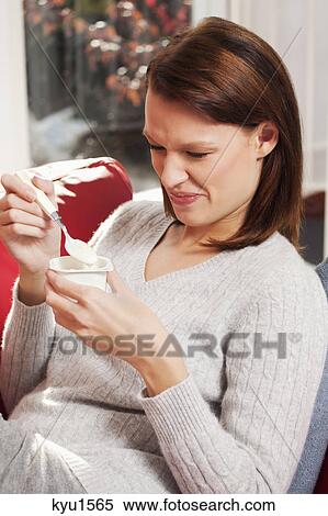 Young woman eating a yogurt View Large Photo Image Stock Photography - Young woman eating a yogurt. Fotosearch