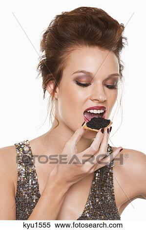 Stock Photography - Young woman eating caviar. Fotosearch