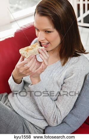 Young woman eating slice of bread View Large Photo Image Stock Photo - Young woman eating slice of bread. Fotosearch