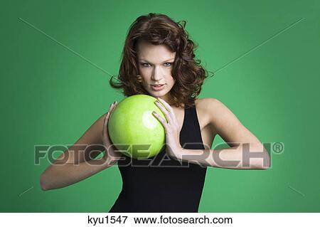 Young woman holding green ball View Large Photo Image Stock Photo - Young woman holding green ball. Fotosearch