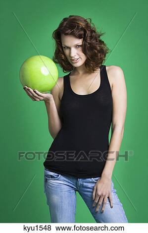 Stock Photo - Young woman holding green ball. Fotosearch