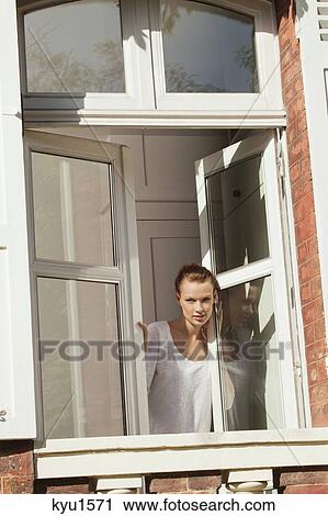 Young woman opening window View Large Photo Image Stock Image - Young woman opening window. Fotosearch