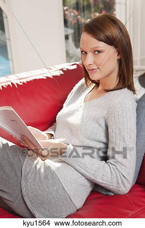 Picture - Young woman reading a book. Fotosearch