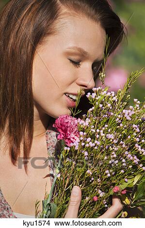 Young woman smelling bouquet View Large Photo Image Picture - Young woman smelling bouquet. Fotosearch