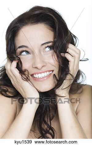 Young woman smiling with hands in hair View Large Photo Image Stock Photo - Young woman smiling with hands in hair. Fotosearch