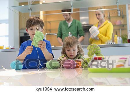 Picture - Boy and his sister playing with woolen balls. Fotosearch