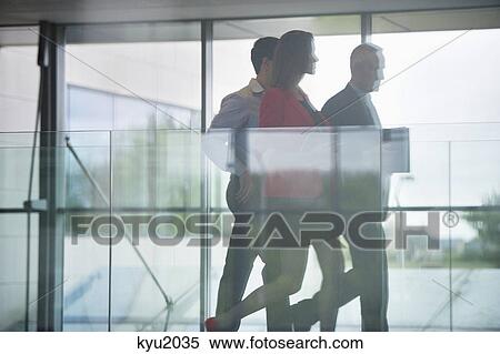 Stock Photography - Business executives walking in an office corridor. Fotosearch