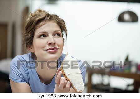 Close-up of a woman eating toast with cream spread on it View Large Photo Image Stock Image - Close-up of a woman eating toast with cream spread on it. Fotosearch