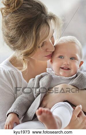 Close-up of a woman kissing her baby View Large Photo Image Stock Image - Close-up of a woman kissing her baby. Fotosearch