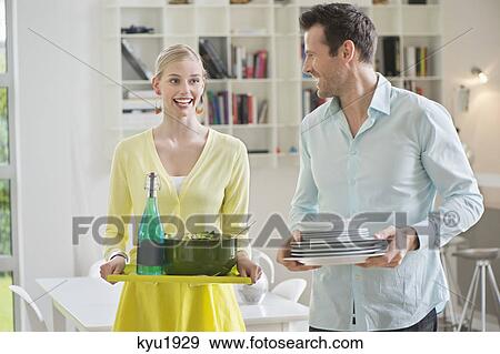 Stock Photo - Couple carrying plates and food for serving. Fotosearch