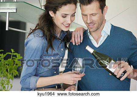 Picture - Couple drinking wine in the kitchen. Fotosearch