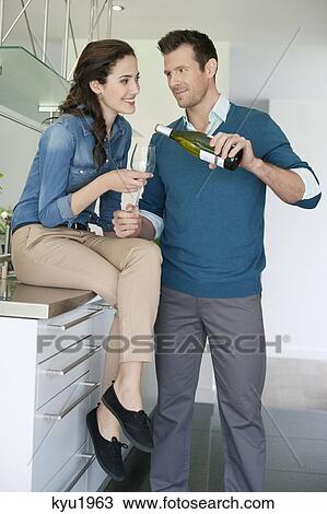Couple drinking wine in the kitchen View Large Photo Image Stock Image - Couple drinking wine in the kitchen. Fotosearch