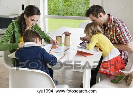 Picture - Couple teaching their children at home. Fotosearch