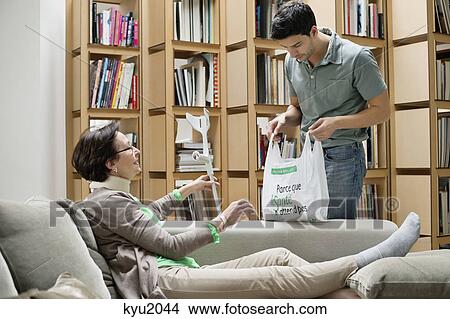 Elderly woman reclining on a couch talking to her son View Large Photo Image Picture - Elderly woman reclining on a couch talking to her son. Fotosearch