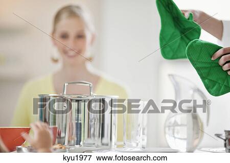 Stock Photo - Female chef serving food on a dining table. Fotosearch