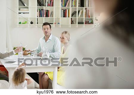 Happy family at dining table View Large Photo Image Stock Photograph - Happy family at dining table. Fotosearch