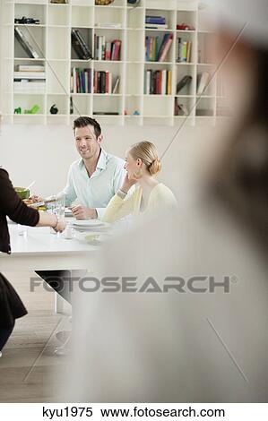 Stock Photography - Happy family at dining table. Fotosearch