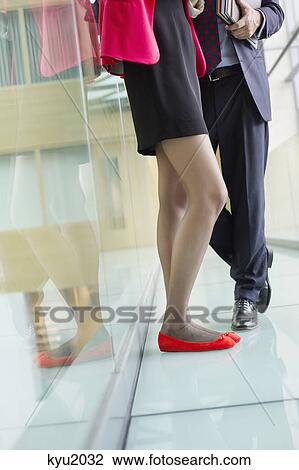 Low section view of business executives standing in an office corridor View Large Photo Image Stock Image - Low section view of business executives standing in an office corridor. Fotosearch