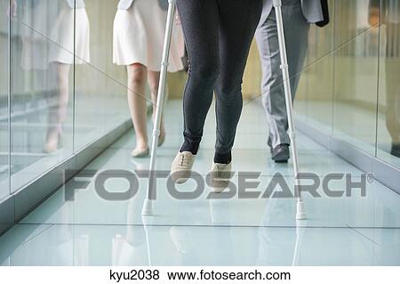 Stock Photo - Low section view of three people walking in the corridor. Fotosearch
