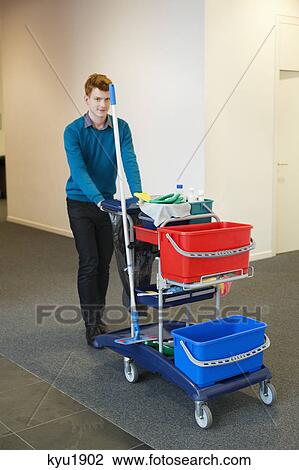 Male cleaner pushing trolley with cleaning equipment View Large Photo Image Stock Image - Male cleaner pushing trolley with cleaning equipment. Fotosearch