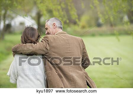 Stock Photo - Man walking with his daughter in a park. Fotosearch