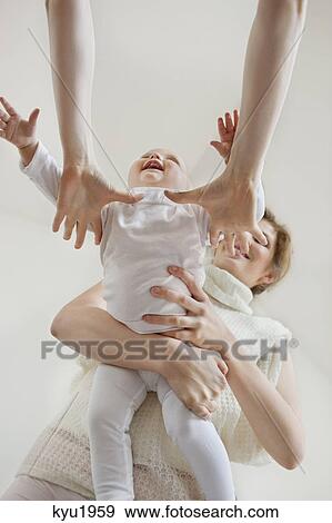 Stock Photo - Person's hands taking a baby girl from her mother. Fotosearch