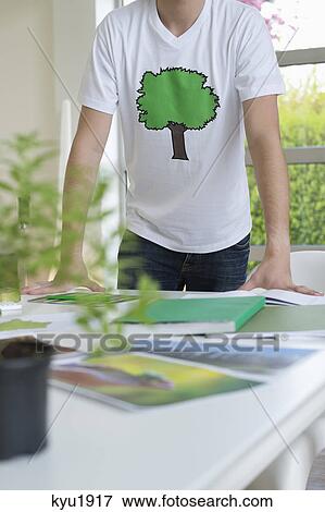 Plant and environmental awareness poster on a table in front of a man View Large Photo Image Stock Photo - Plant and environmental awareness poster on a table in front of a man. Fotosearch