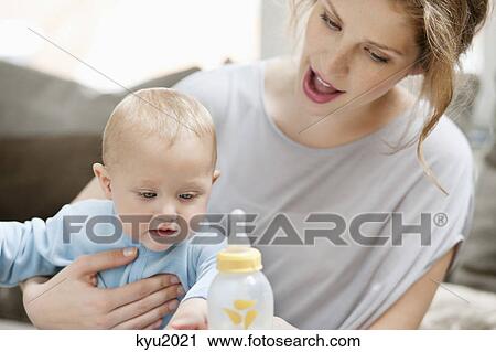Woman feeding milk to her daughter View Large Photo Image Stock Image - Woman feeding milk to her daughter. Fotosearch
