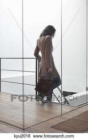 Stock Photograph - Woman moving down stairs. Fotosearch