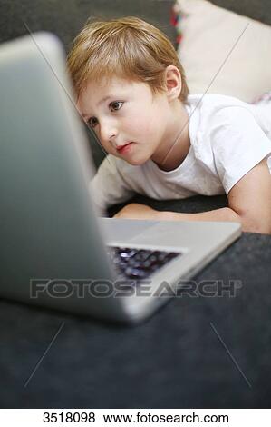 5 years old boy looking at a computer View Large Photo Image Stock Photo - 5 years old boy looking at a computer. Fotosearch